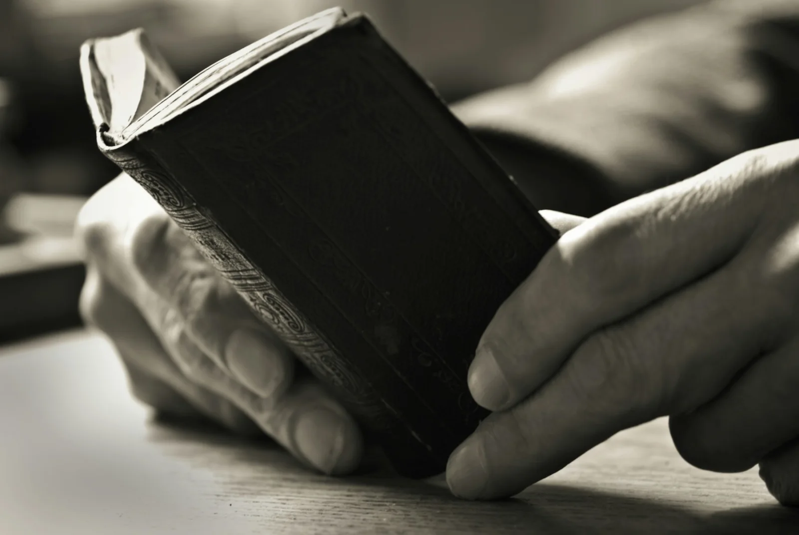 Hands resting beside an open Bible during a quiet moment